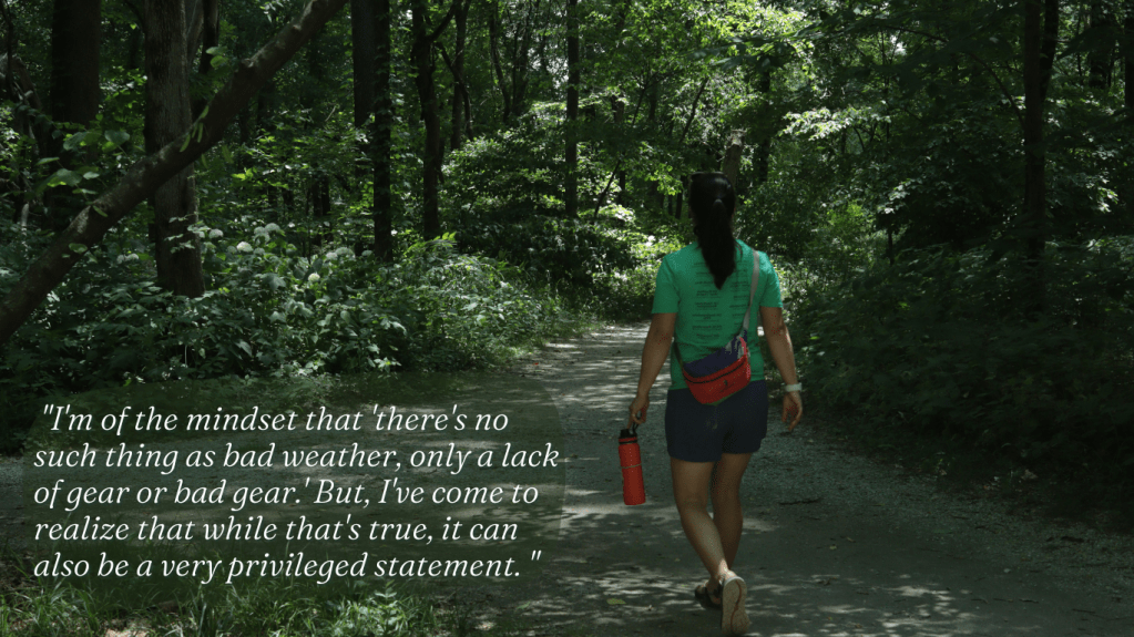 White text quote over a dark photo of Julie walking on a gravel path through the woods, "I'm of the mindset that there's no such thing as bad weather, only a lack of gear or bad gear. But, I've come to realize that while that's true, it can also be a very privileged statement."